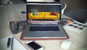 MacBook Pro allumé à côté d'une tasse grise