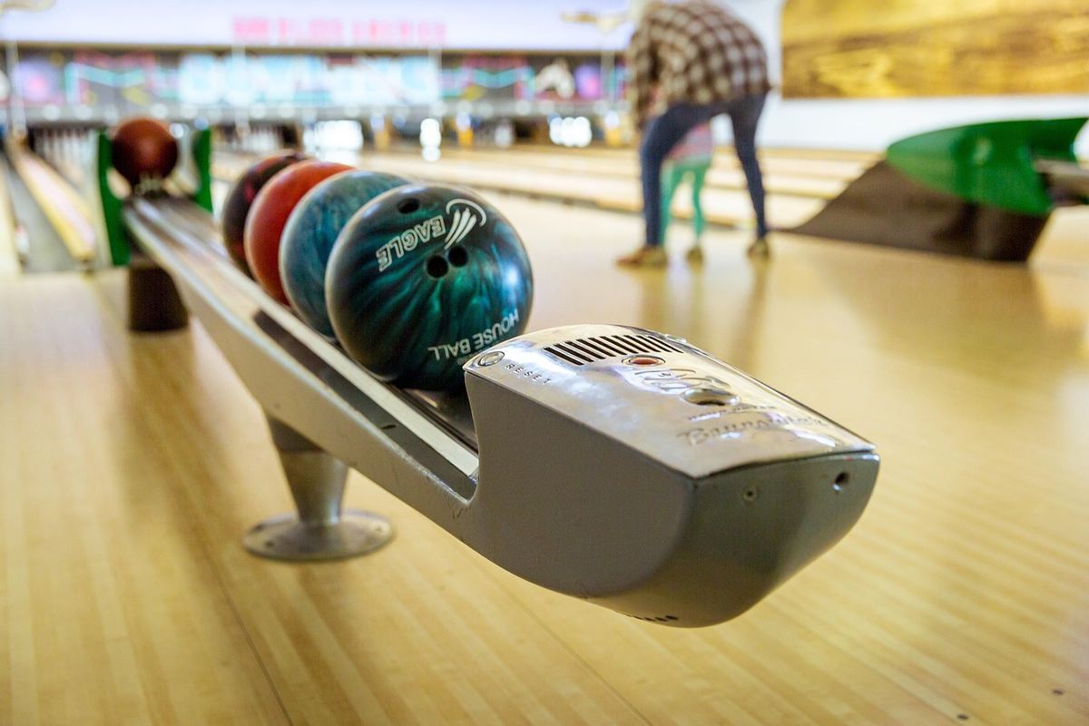 Boules de bowling sur chariot, allées, joueur en arrière-plan