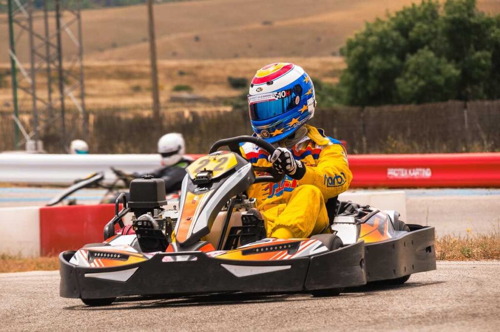 Un coureur en kart jaune pilote sur circuit extérieur