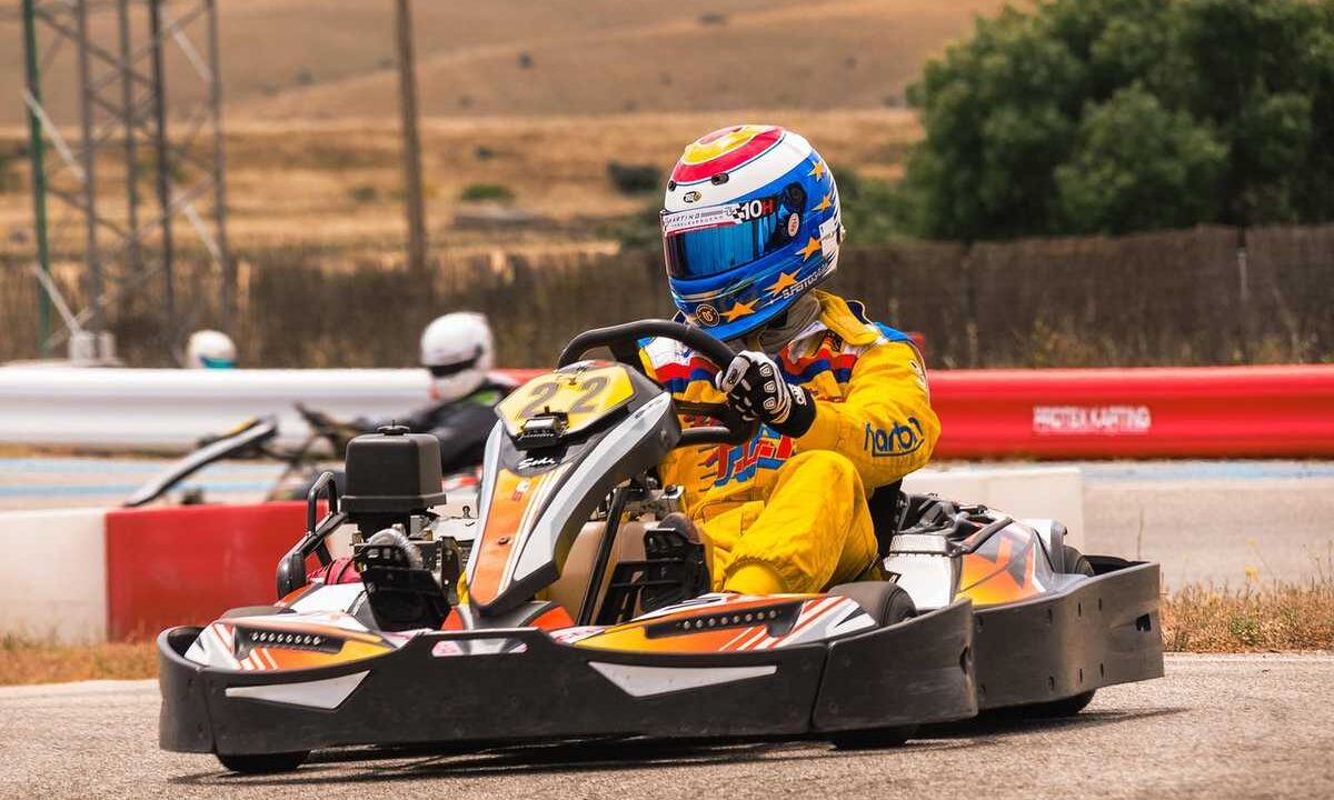 Un coureur en kart jaune pilote sur circuit extérieur