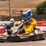 Un coureur en kart jaune pilote sur circuit extérieur