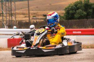 Un coureur en kart jaune pilote sur circuit extérieur