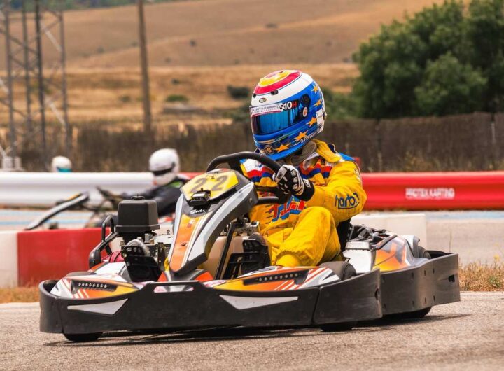 Un coureur en kart jaune pilote sur circuit extérieur