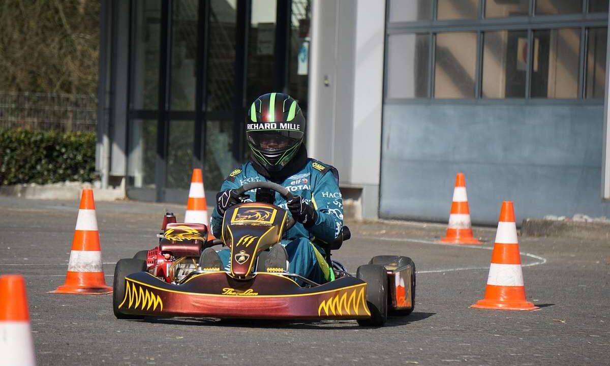 Un conducteur en karting navigant entre cônes orange sur piste