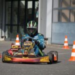 Un conducteur en karting navigant entre cônes orange sur piste