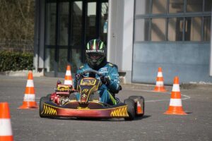 Un conducteur en karting navigant entre cônes orange sur piste