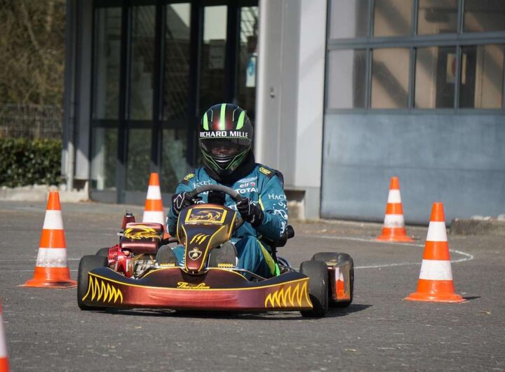 Un conducteur en karting navigant entre cônes orange sur piste