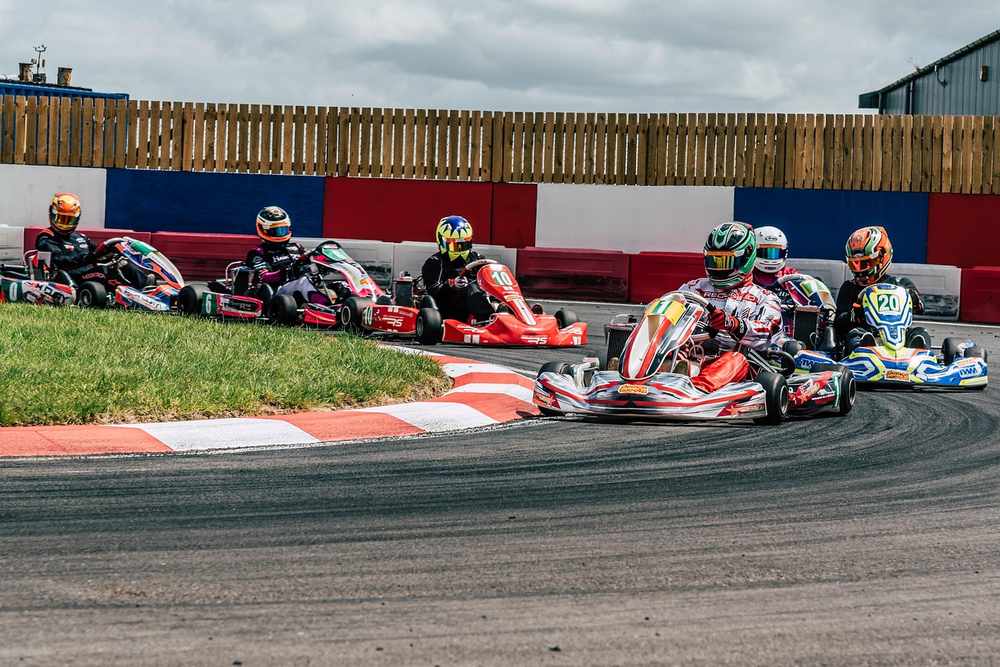 Des kartingistes pilotent leurs karting sur un virage de circuit Des kartingistes pilotent leurs karting sur un virage de circuit
