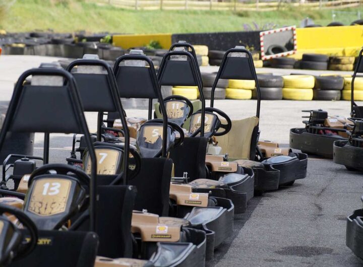 Des karting noirs alignés sur piste, prêts à être pilotés